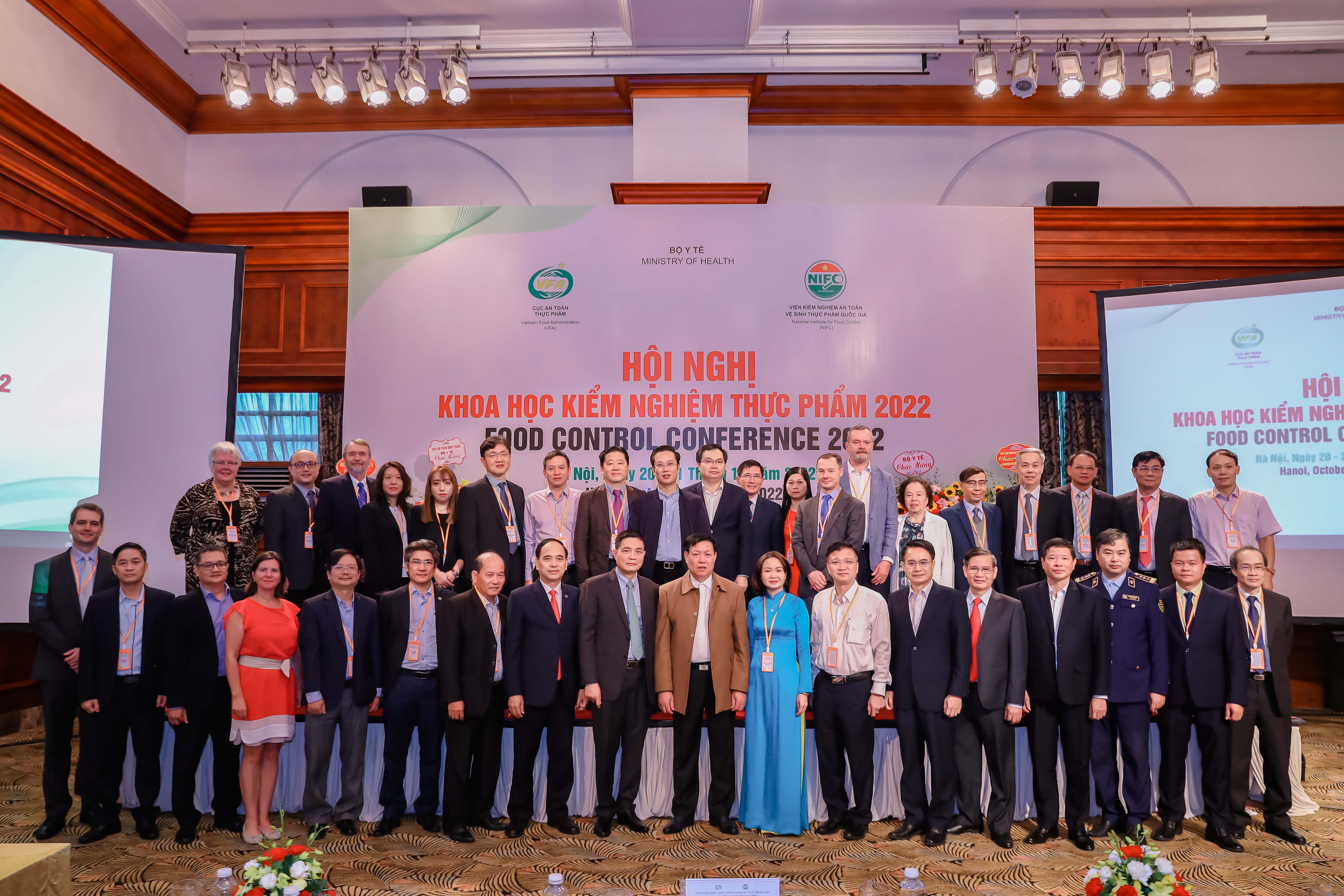 Group photo of the conference participants in front of a poster.